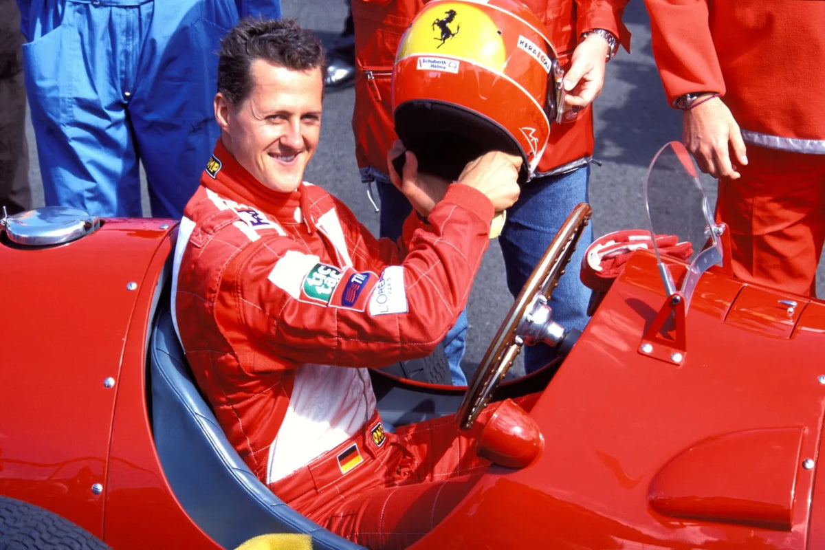 Michael Schumacher sits in a vintage Ferrari 