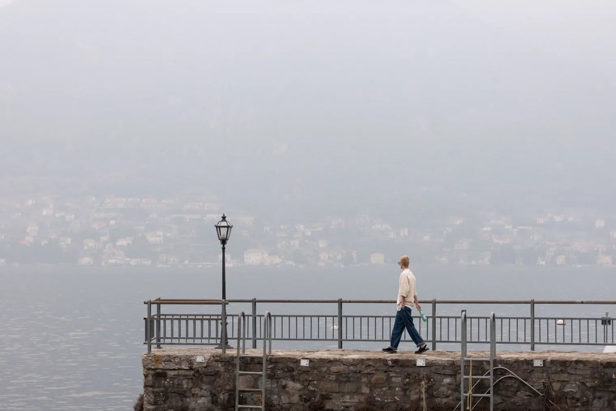 Man walking in distance on pier with Dr. Martens’ Jorge Mule on feet
