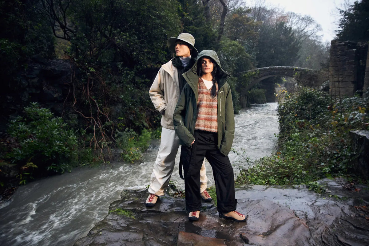 Duo wearing KEEN’s Jasper outdoor clothing whilst stood next to a river