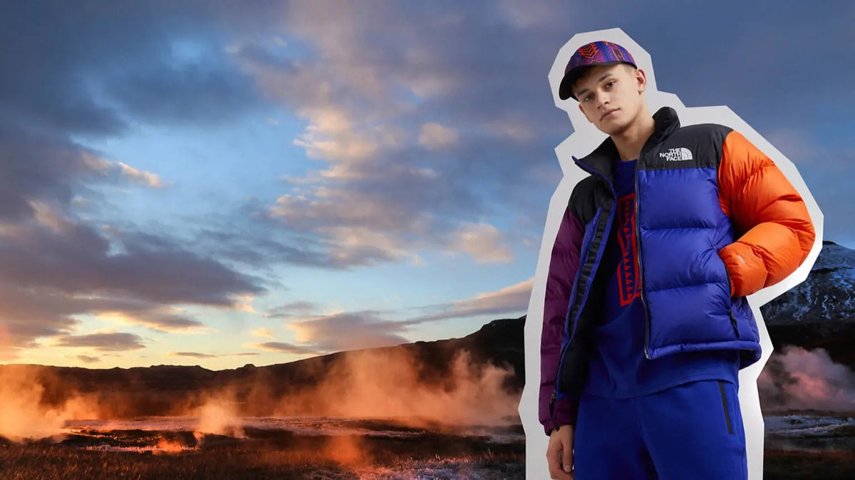 A man wearing The North Face with a sunset scene in the background.