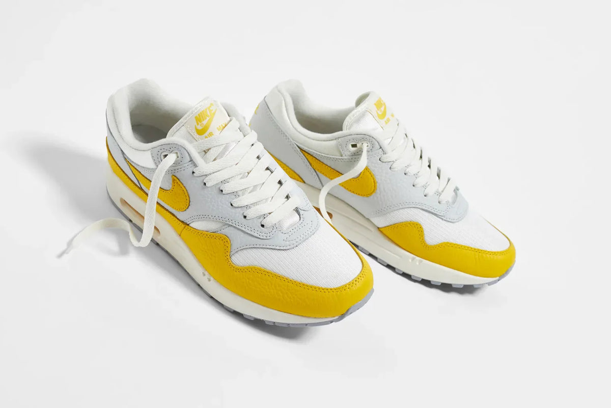 The NIKE AIR MAX 1 W "TOUR YELLOW" sneakers.