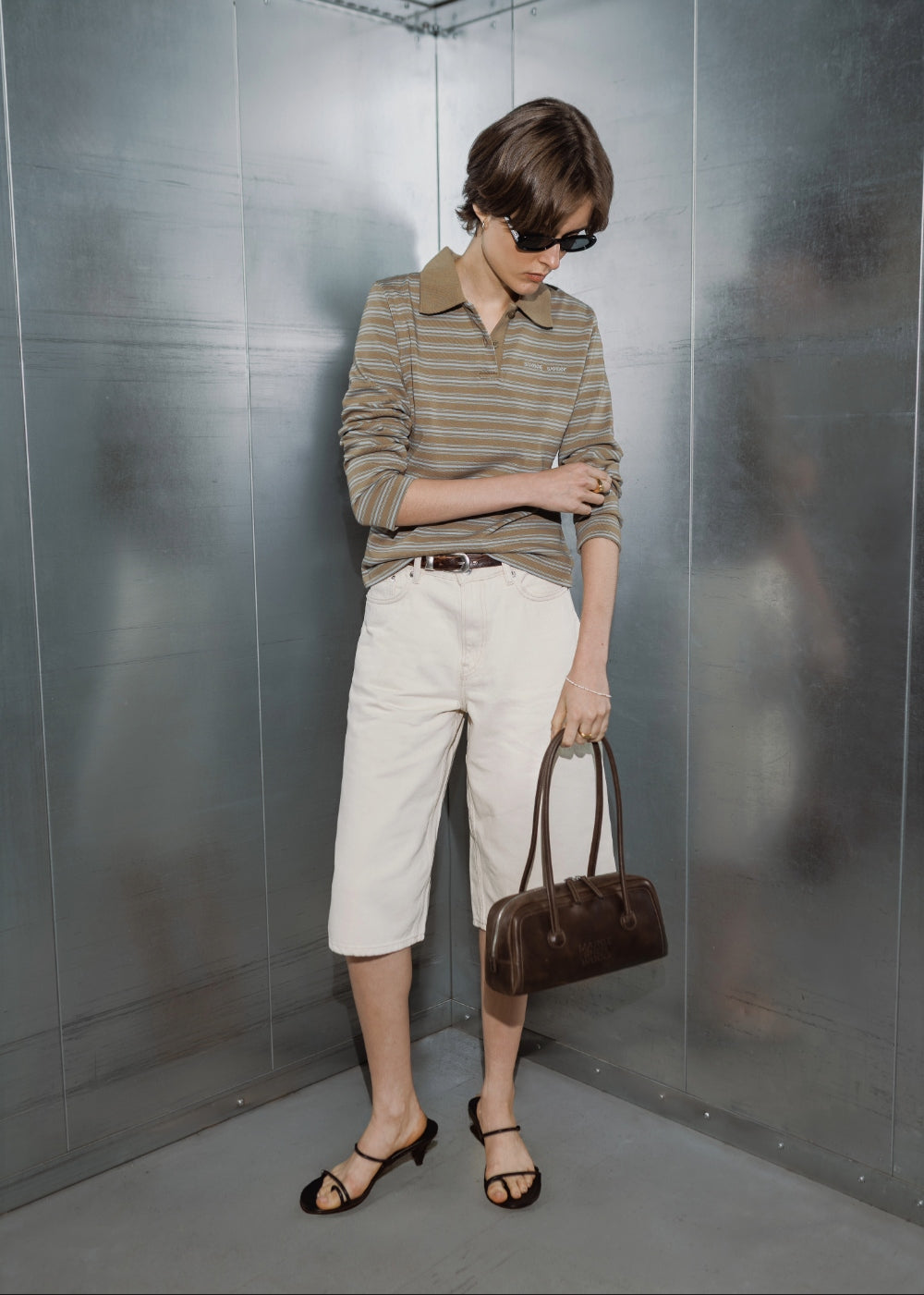 A model wears a striped polo shirt and white denim shorts