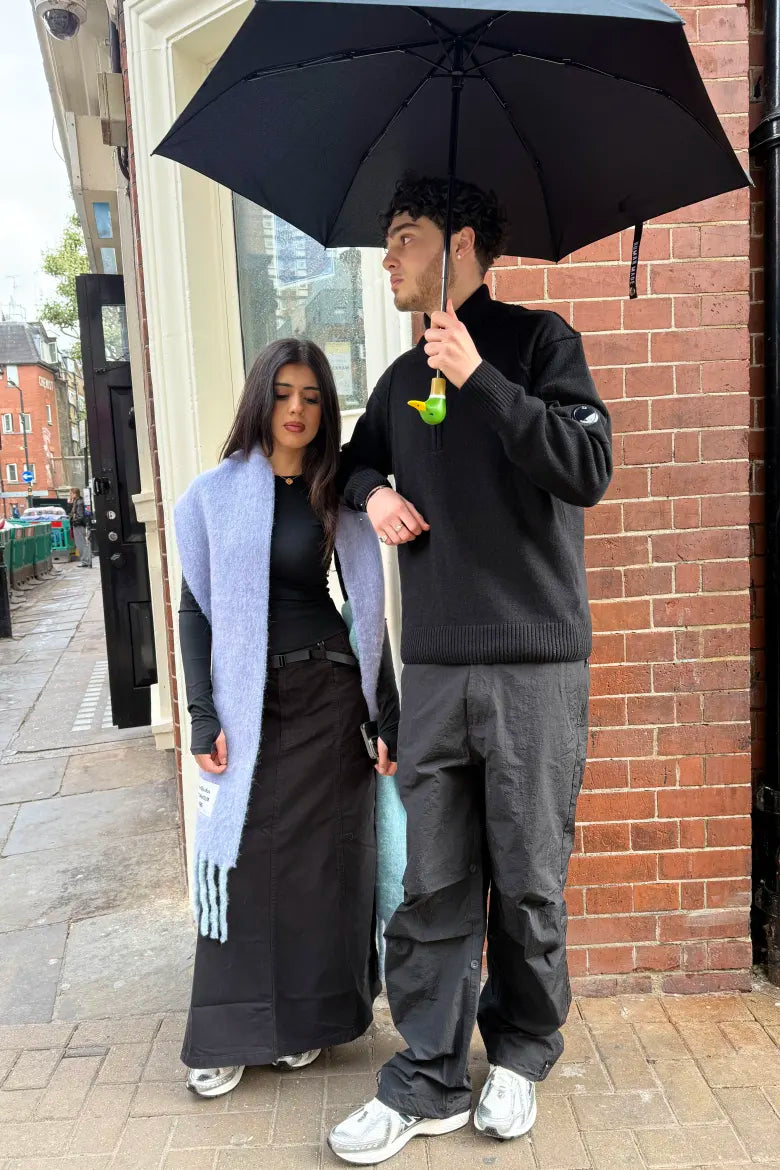 All‑black streetwear looks on a man and woman, featured in an END. editorial on styling the New Balance M1906R sneaker.