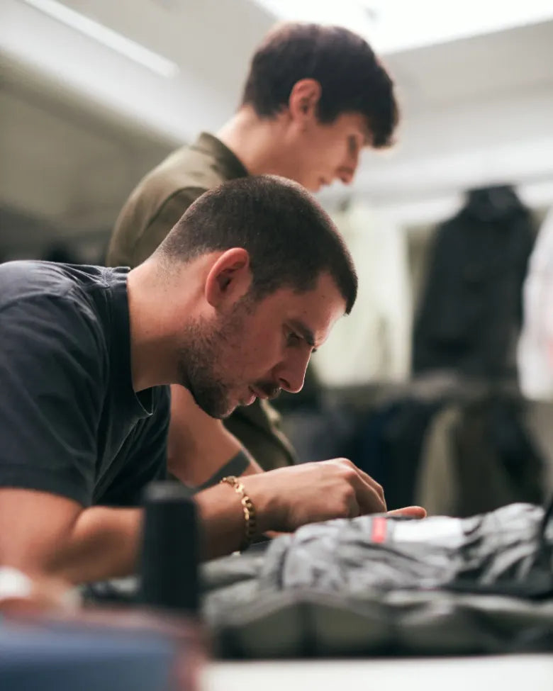 Artisans work on clothing in a workshop
