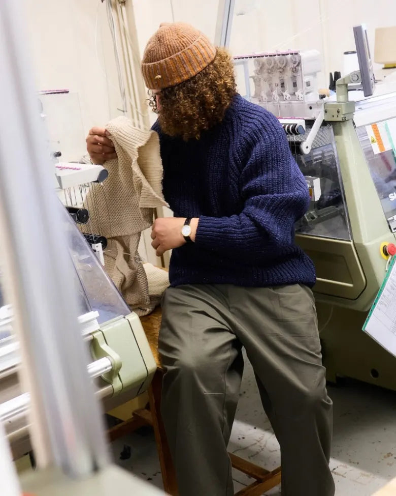 Jojo inspecting a garment that has just been woven in a machine