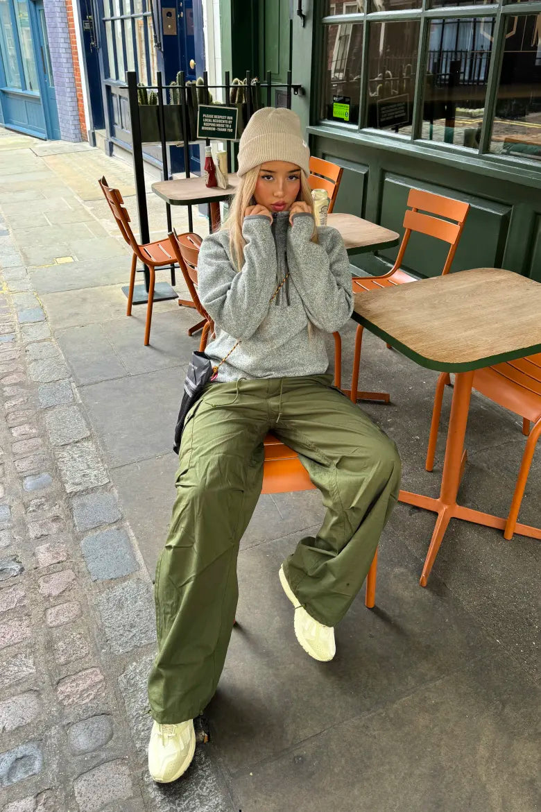 Streetwear look with a woman wearing a hoodie and cargo trousers, from an END. editorial about ways to style the New Balance M1906R sneaker.