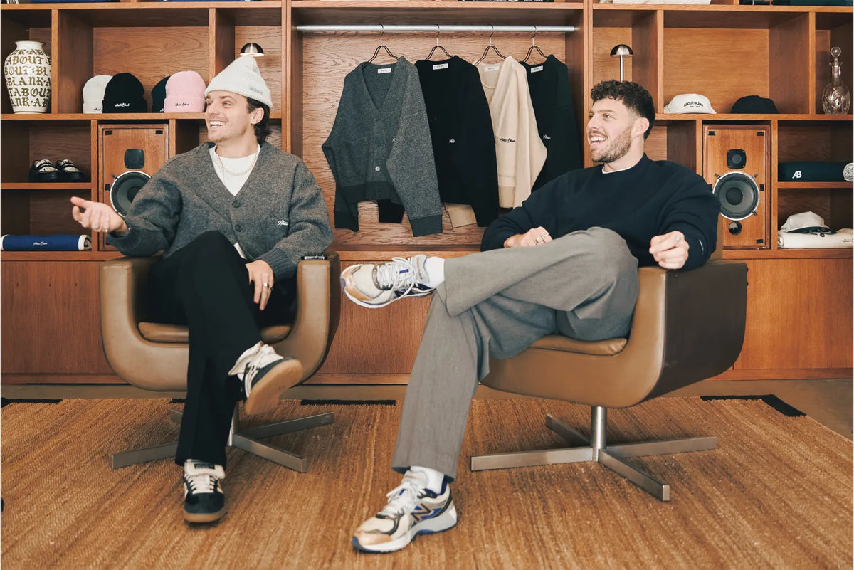 The founders of about:blank sitting on chairs and smiling.