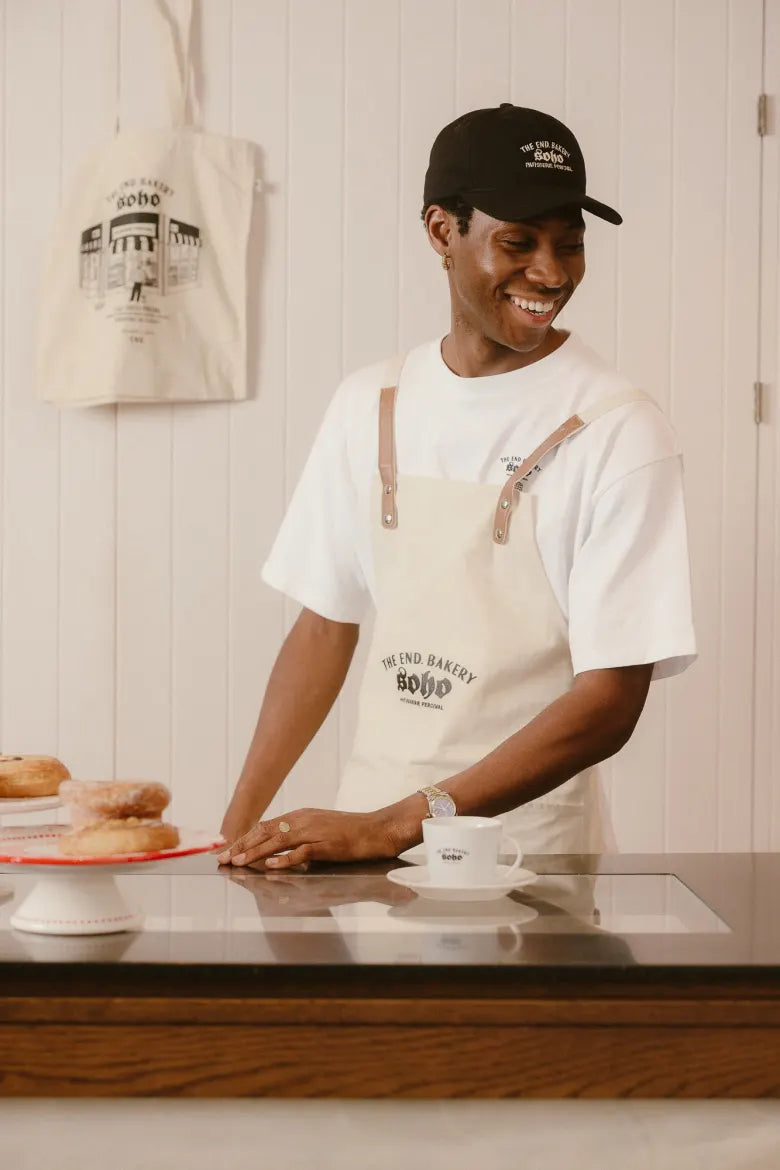 Man in bakery wearing a Percival hat and tee
