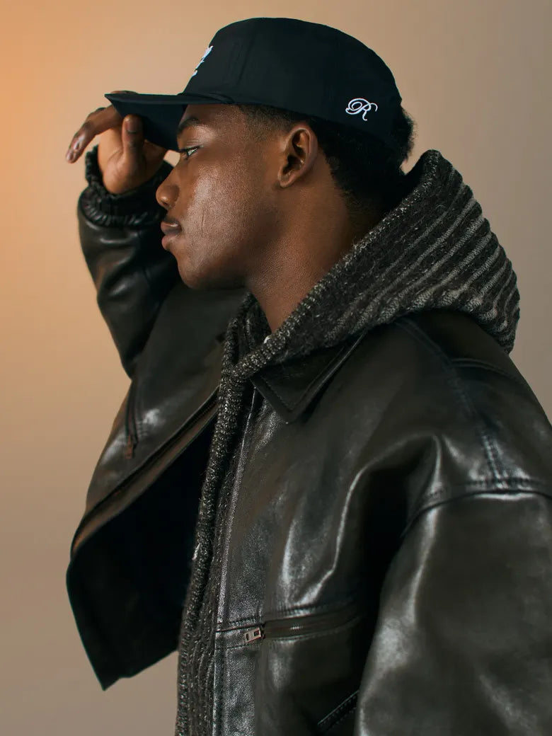 Man wearing leather jacket and cap