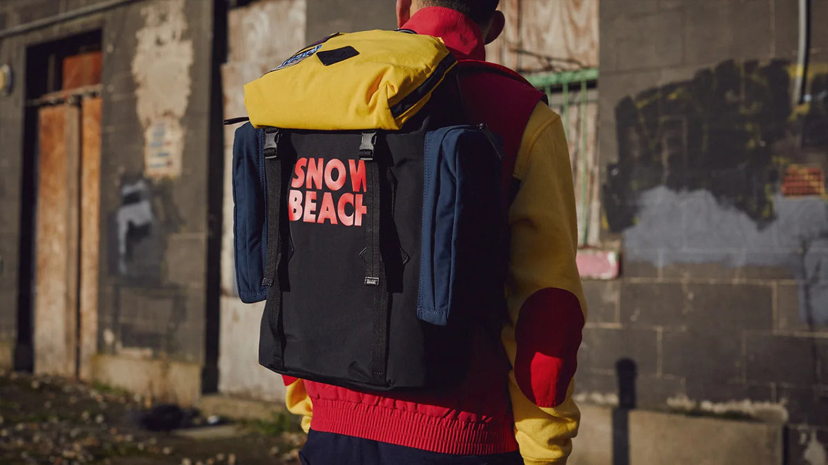 Editorial image of a man wearing a bold, colourful Polo Ralph Lauren Snow Beach backpack from the commemorative capsule.
