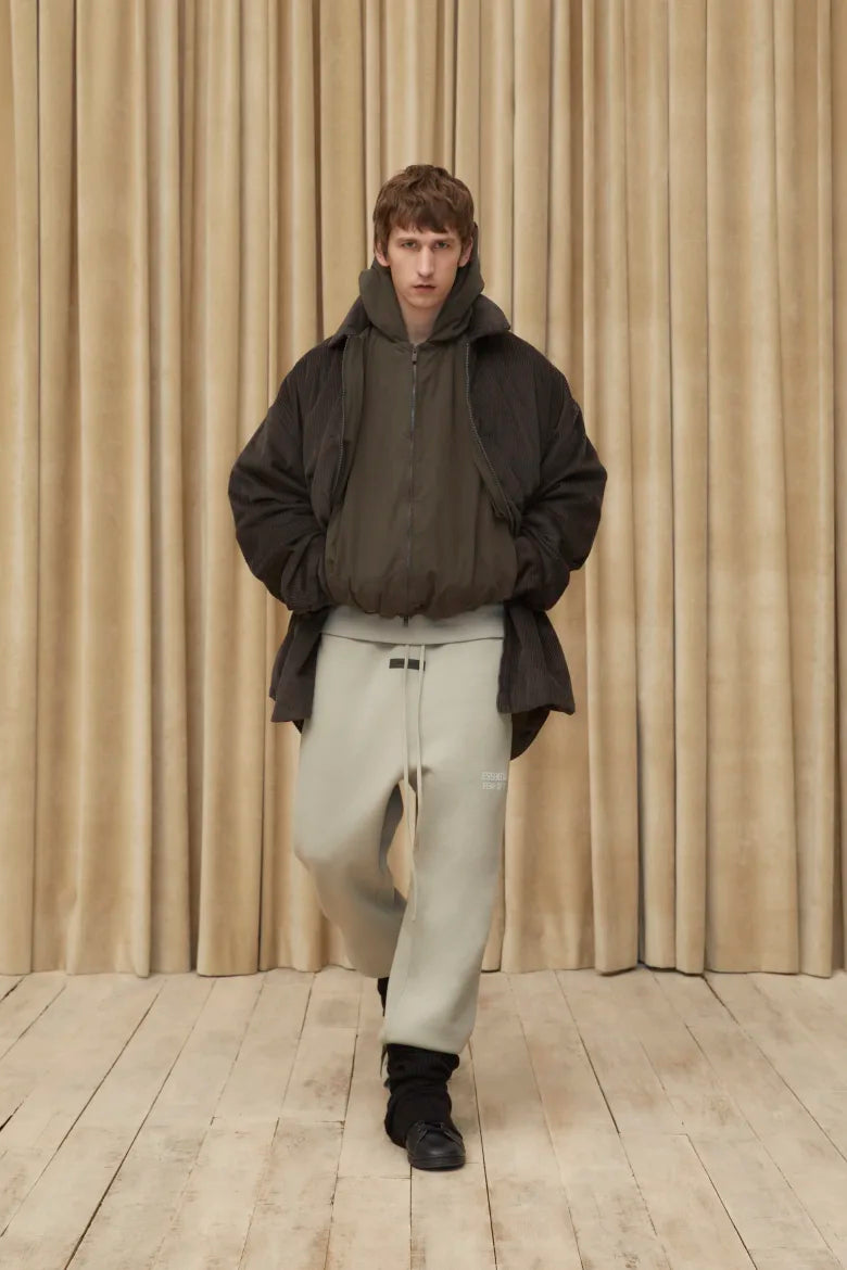 Man wearing hoodie and sweat pants from the Fear of God ESSENTIALS Spring 23 collection