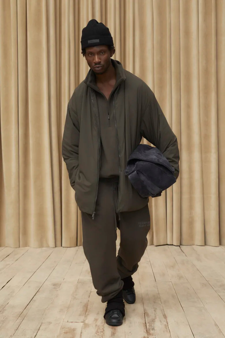 Man wearing jacket and sweat pants from the Fear of God ESSENTIALS Spring 23 collection