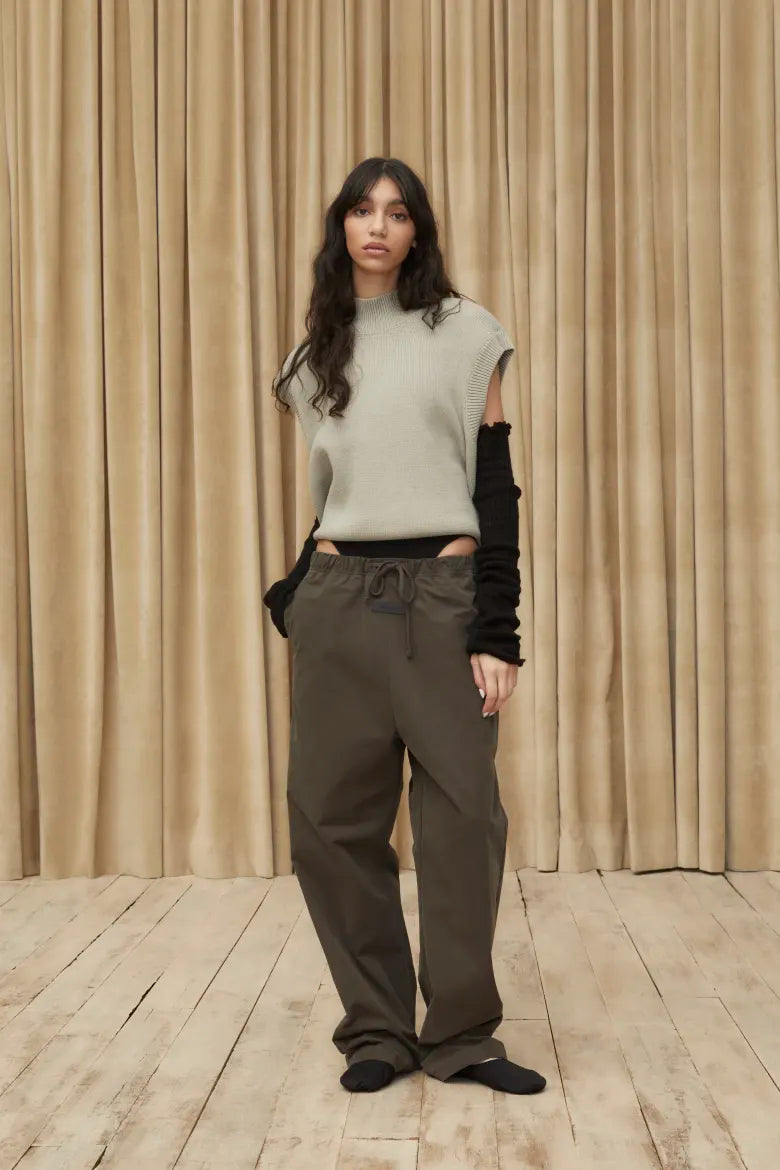 Woman wearing knit top and sweat pants from the Fear of God ESSENTIALS Spring 23 collection