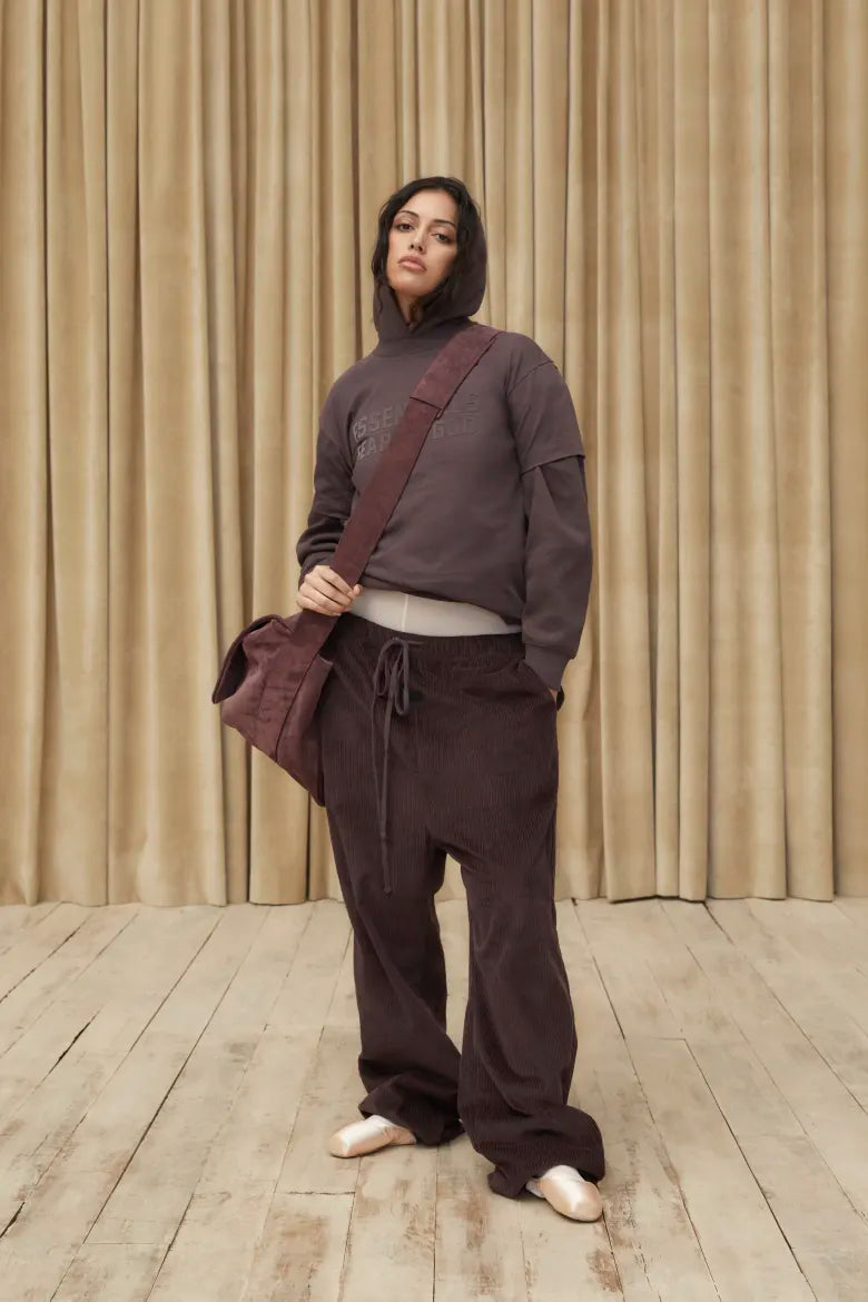 Woman wearing hoodie and sweat pants from the Fear of God ESSENTIALS Spring 23 collection