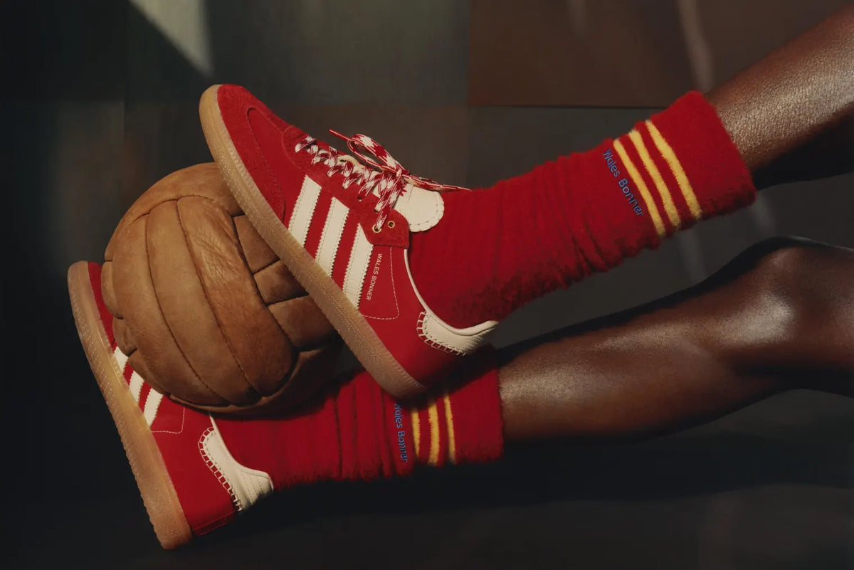 A person wearing adidas x Wales Bonner sneakers with a football.