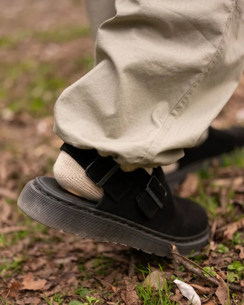 Man walking through park with Dr. Martens’ Jorge Mule on feet