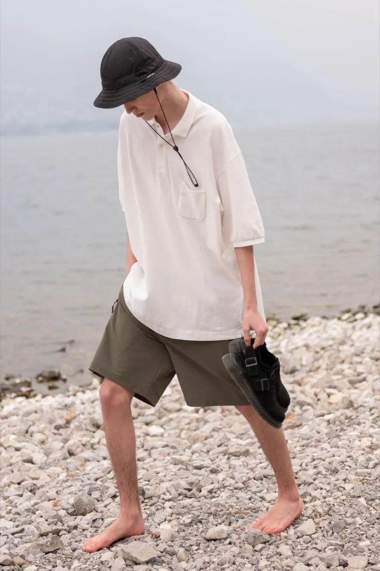 Man walking on beach with Dr. Martens’ Jorge Mule in hand