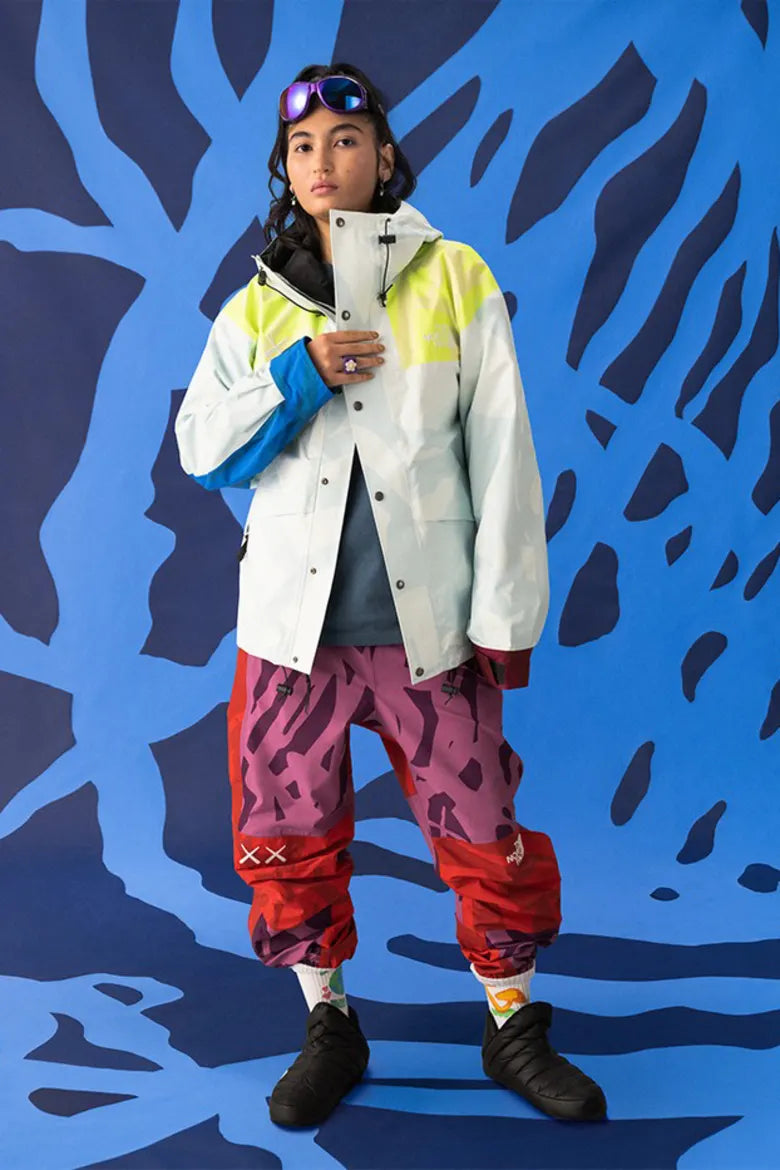 Model wearing vibrant clothing from The North Face x KAWS "XX KAWS" collection