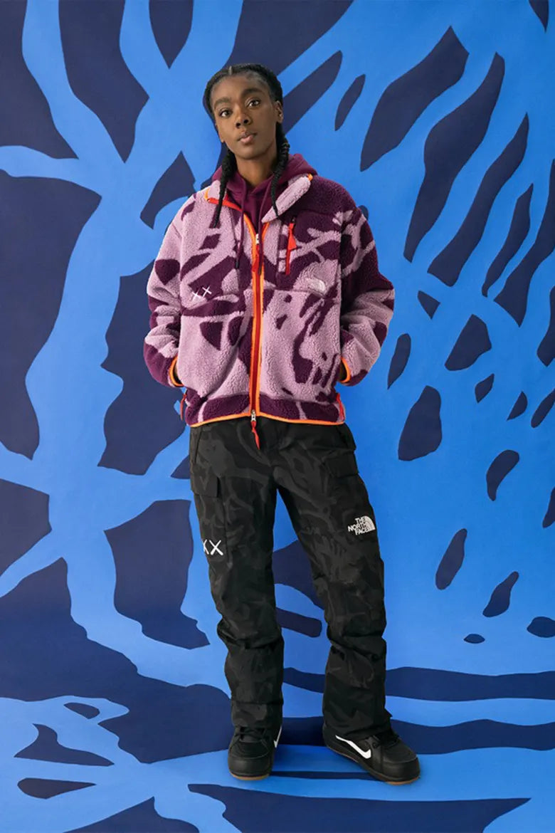 Model wearing vibrant outdoor clothing from The North Face x KAWS "XX KAWS" collection