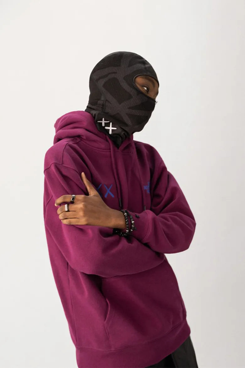 Model wearing vibrant clothing and balaclava from The North Face x KAWS "XX KAWS" collection