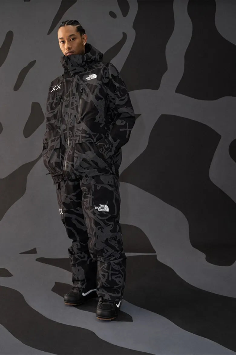 Model wearing monochrome outdoor clothing from The North Face x KAWS "XX KAWS" collection