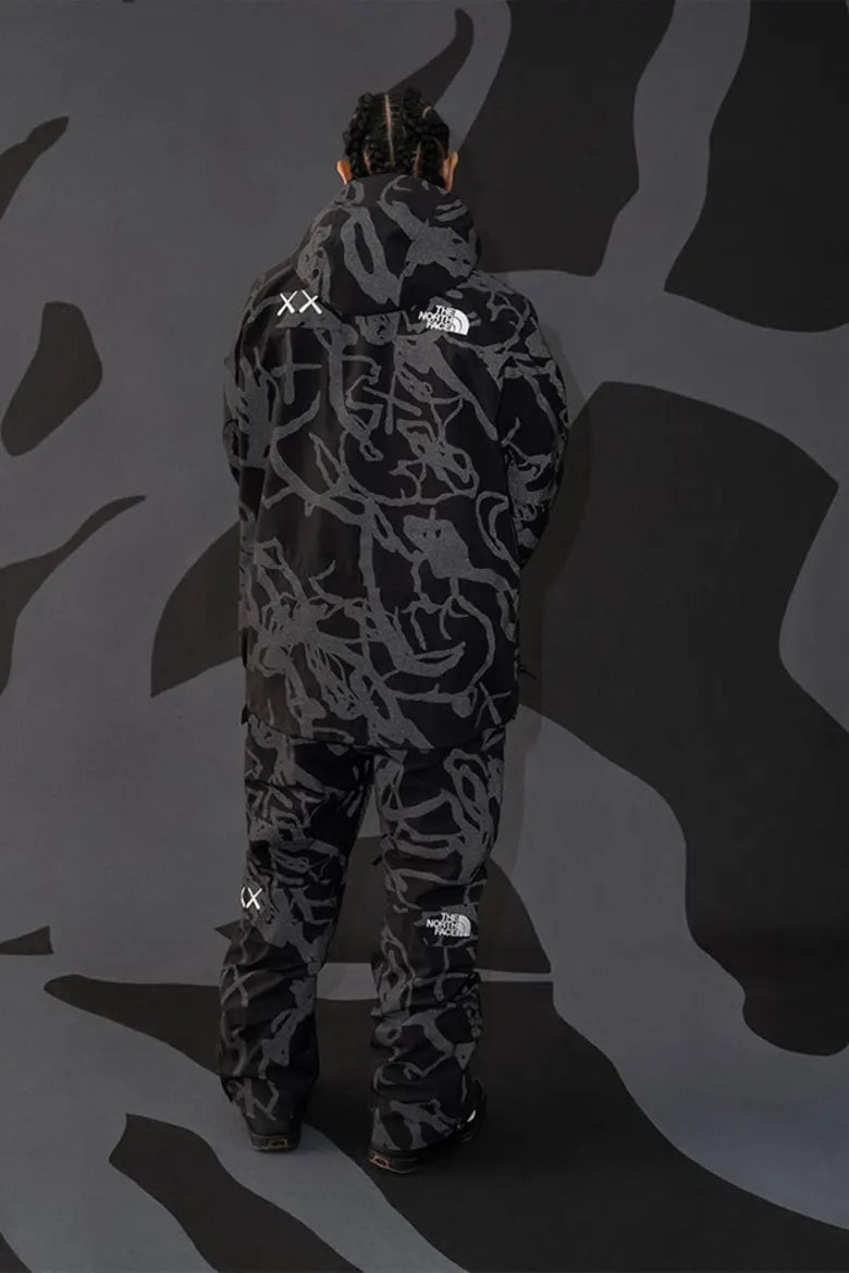 Model wearing monochrome outdoor clothing from The North Face x KAWS "XX KAWS" collection