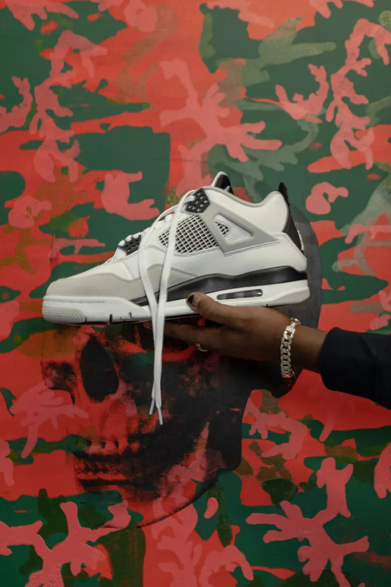 Model holding Air Jordan 4 "Military Black" sneaker