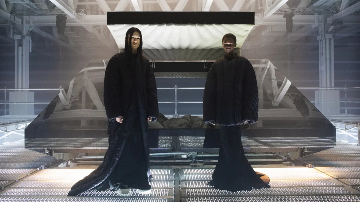 The Moncler x Rick Owens collaboration photo shoot scene with two models wearing the collection.