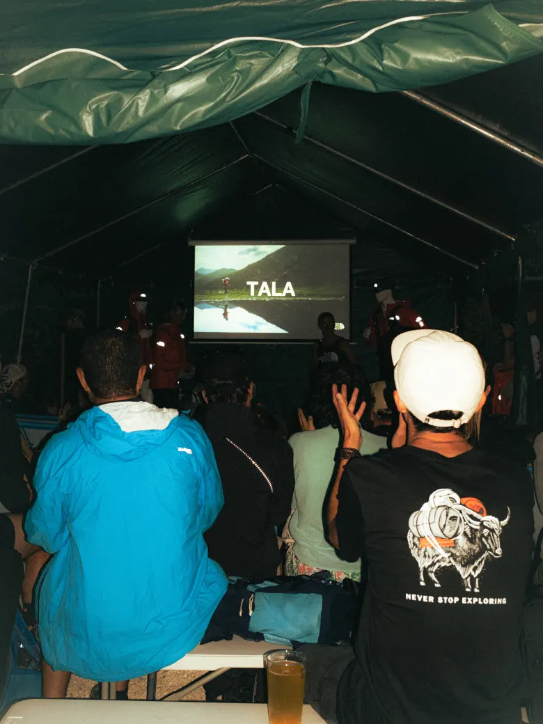 People watching a film screening in a tent about ultra running.