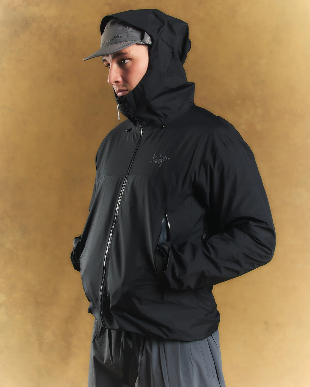 A man wearing a cap and an Arc'teryx coat.