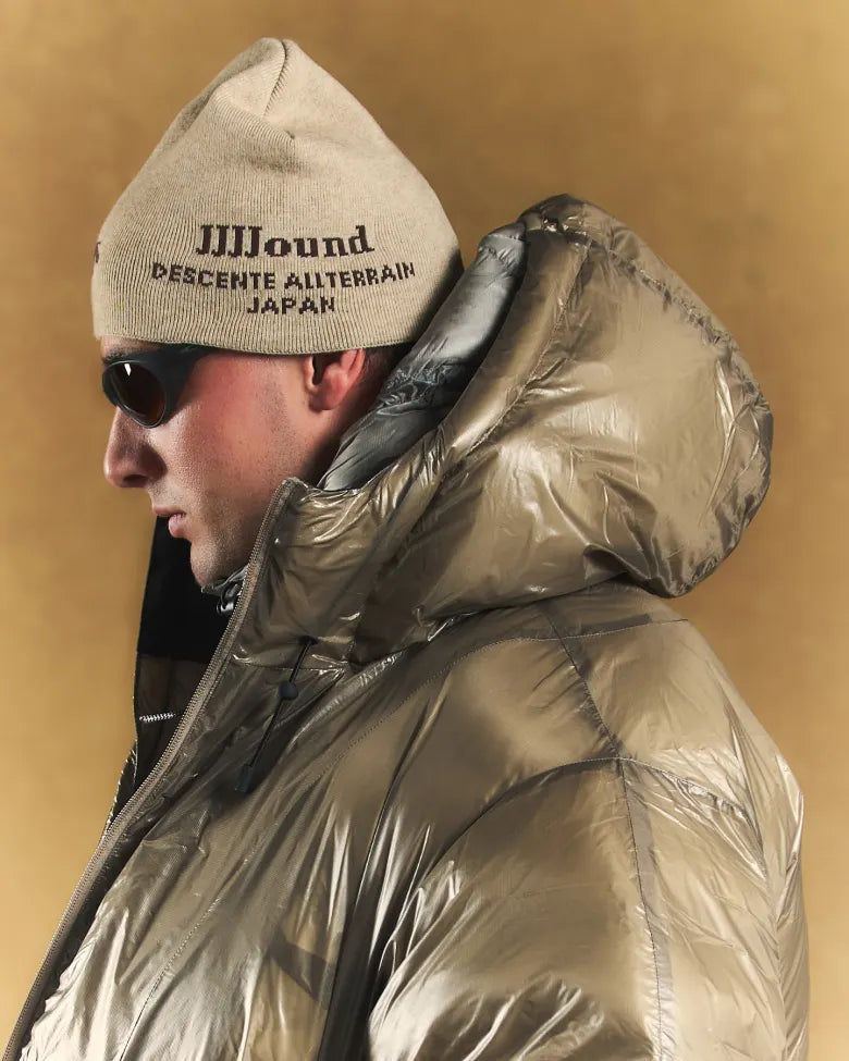 A man wearing a beanie and a puffer coat.