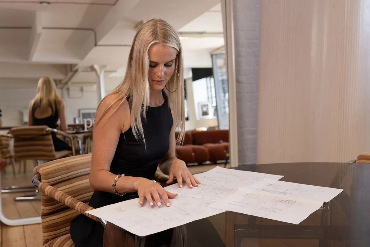 Isabella Weatherby, founder of Peachy Den, looking at designs.
