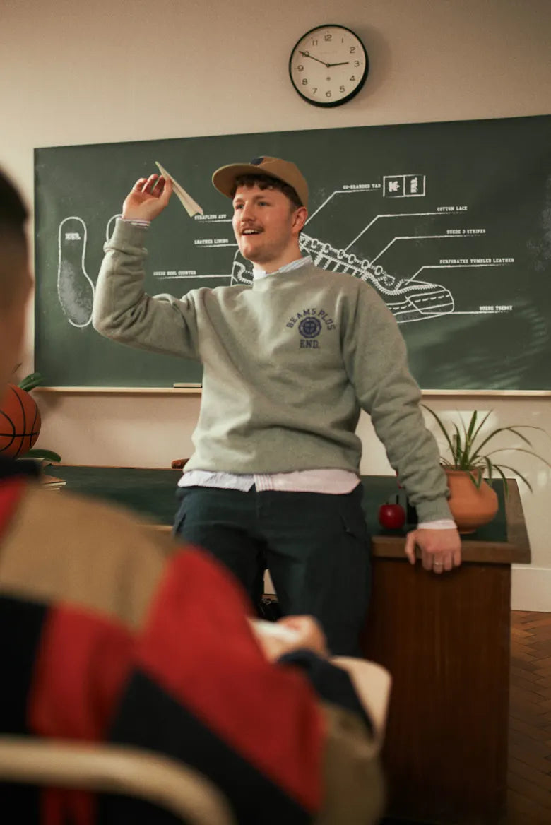 People in a classroom wearing the END. x Beams Plus Varsity collection.